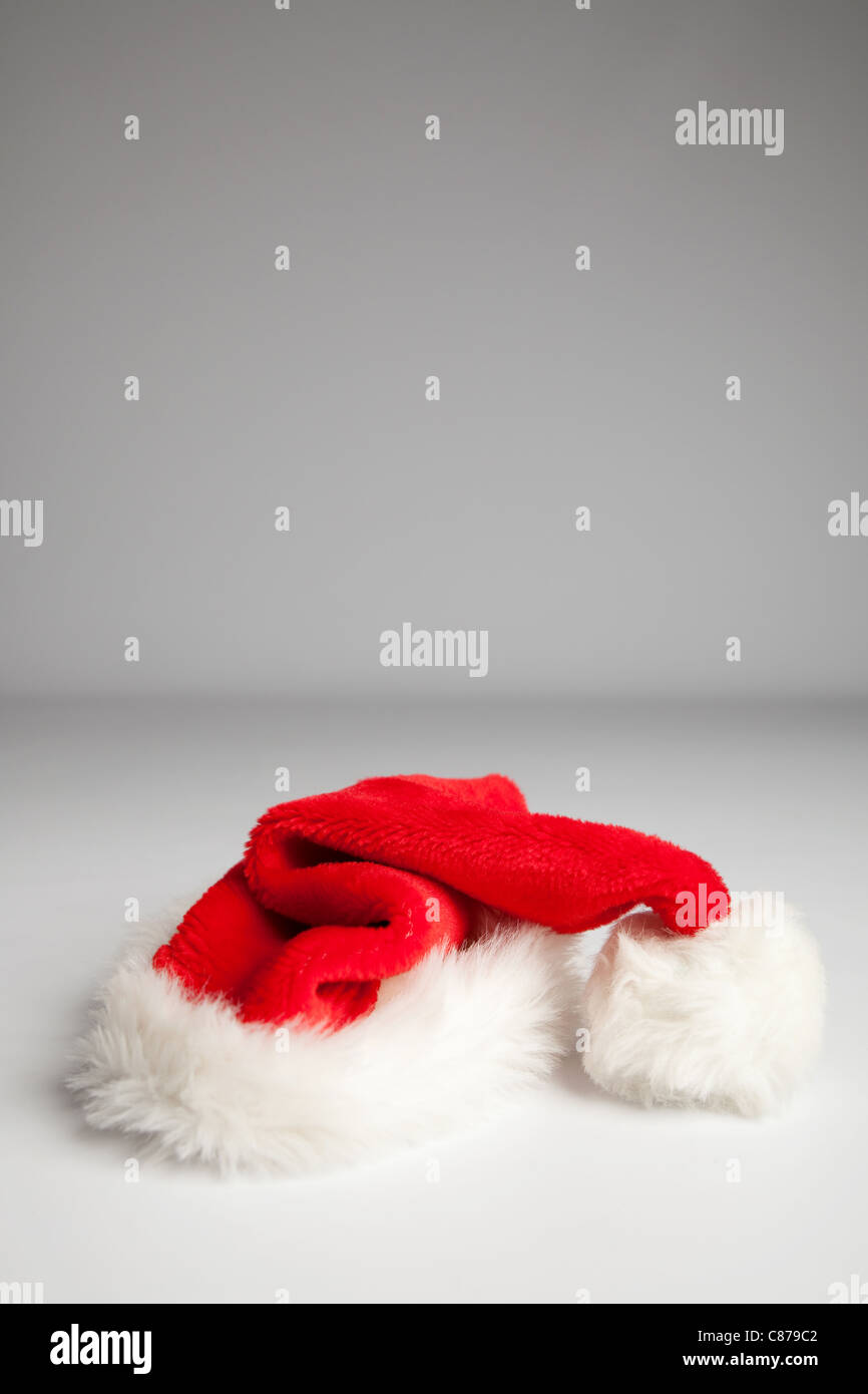 A Santa hat, against a grey studio background Stock Photo - Alamy