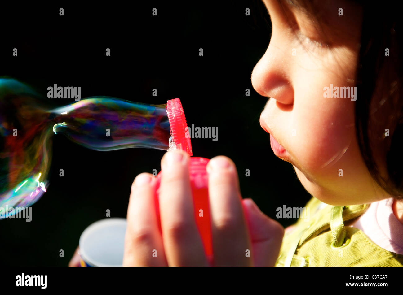 Little Girl making soap bubbles Stock Photo - Alamy