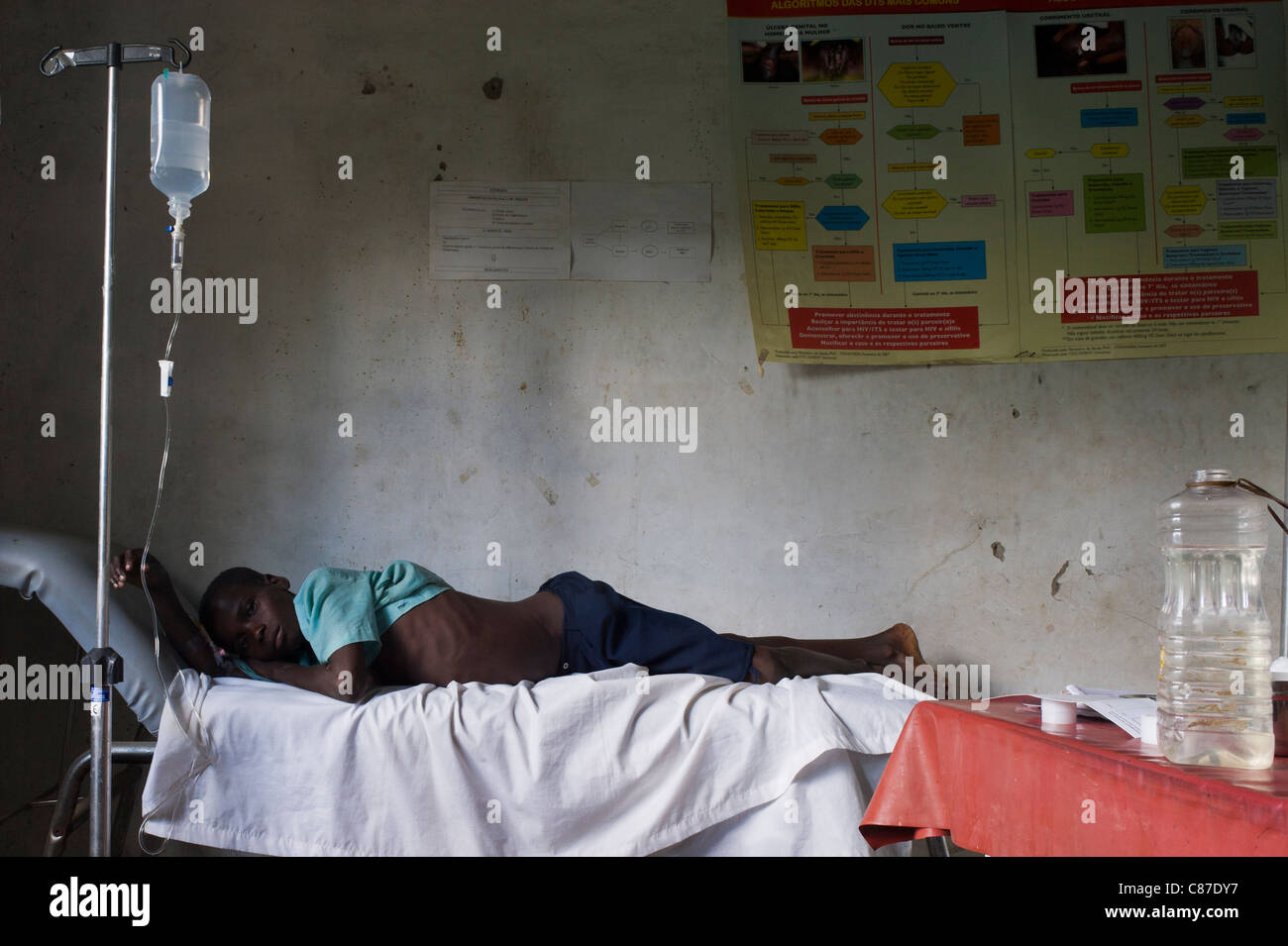 Patient with an intravenous drip tubing attached in poorly equiped dispensay, Quelimane Mozambique Stock Photo