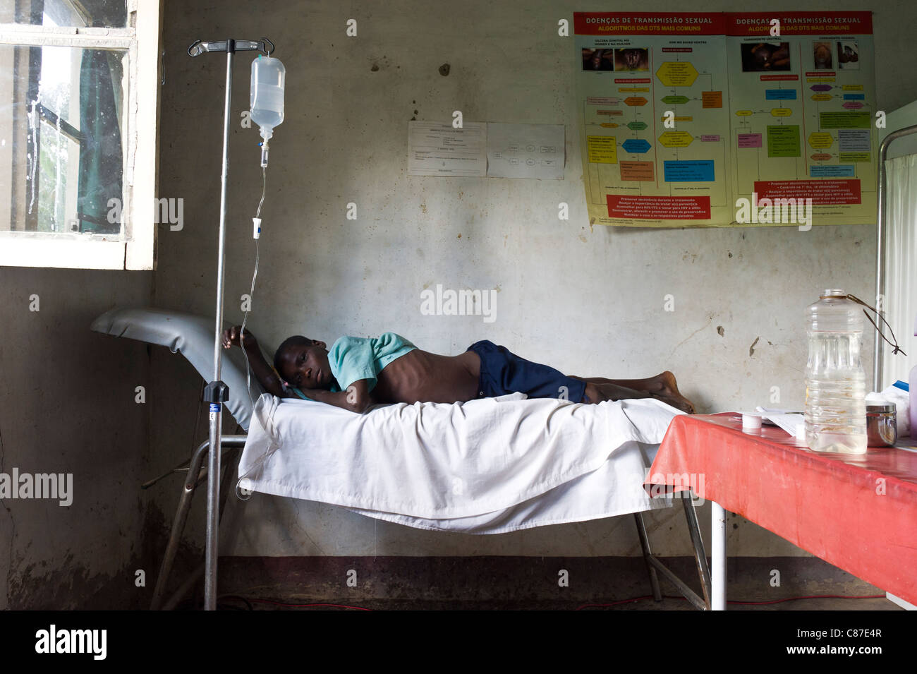 Patient with an intravenous drip tubing attached in poorly equiped dispensay, Quelimane Mozambique Stock Photo