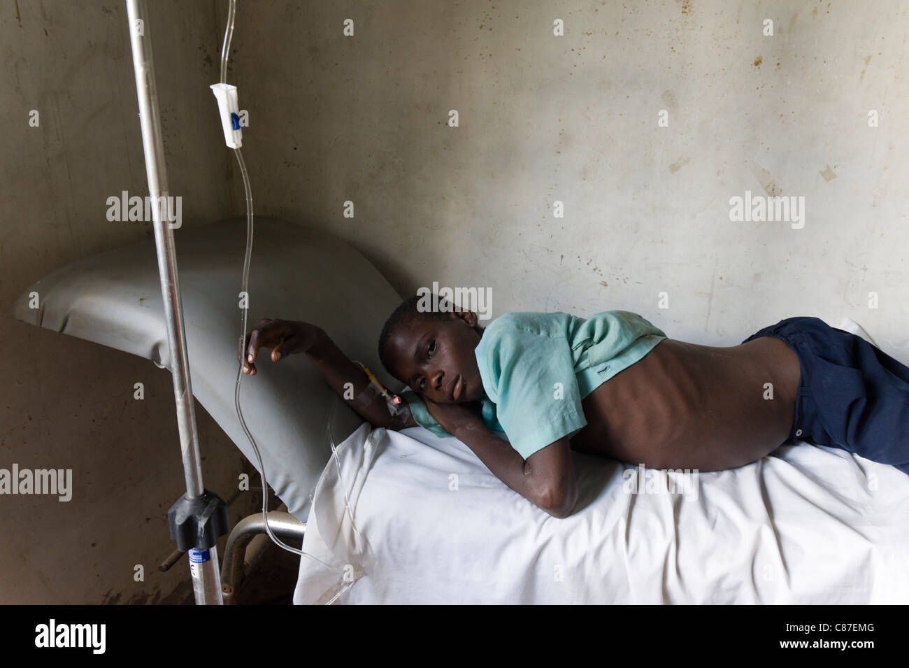 Patient with an intravenous drip tubing attached in poorly equipped dispensary, Quelimane Mozambique Stock Photo