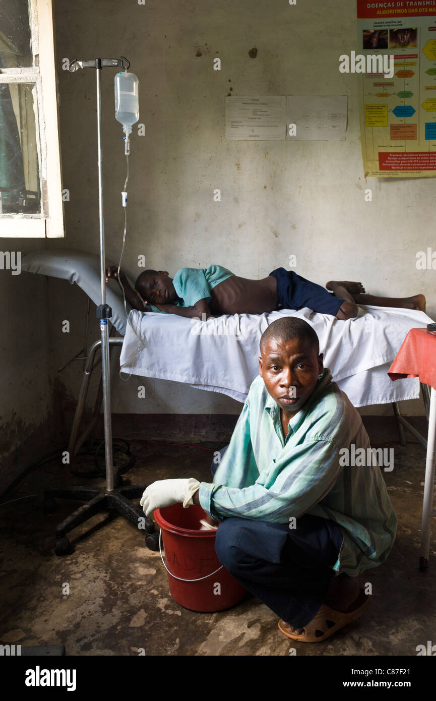 Intravenous patient and health worker cleaning the floor in a dispensary in Quelimane Mozambique Stock Photo