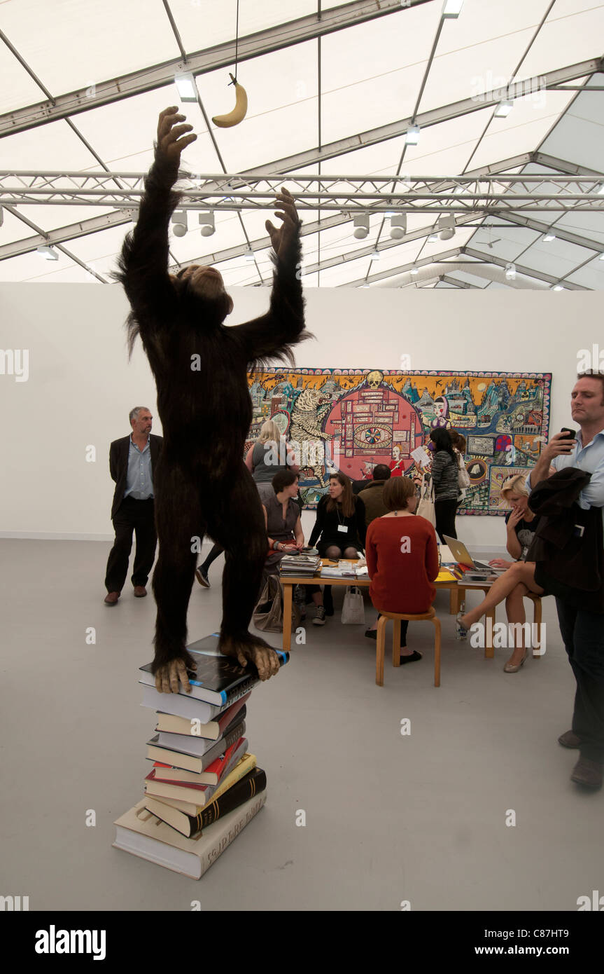 Frieze art fair 2011 .Visitors in front of Elmgreen and Dragset , The Fruit of Knowledge ,an ape standing on a pile of art books Stock Photo