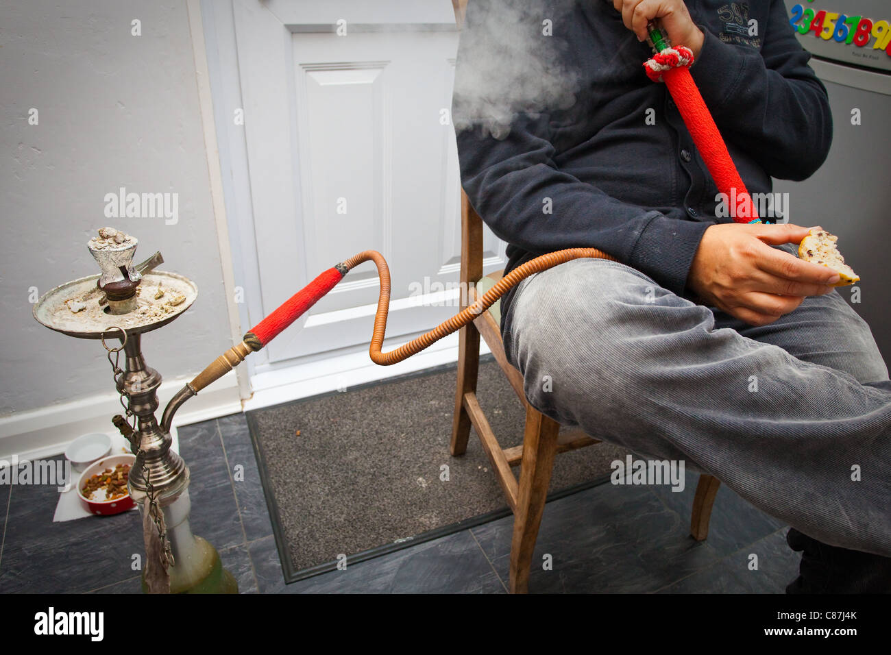 An unidentifiable man smoking a shisha pipe Stock Photo