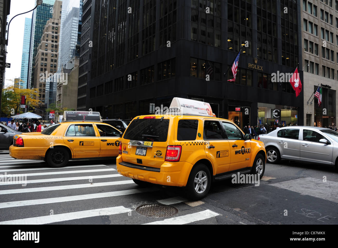 Road jam crossroads 5th Avenue yellow taxis meeting East 53rd Street cars, front Rolex Building, Midtown Manhattan, New York Stock Photo