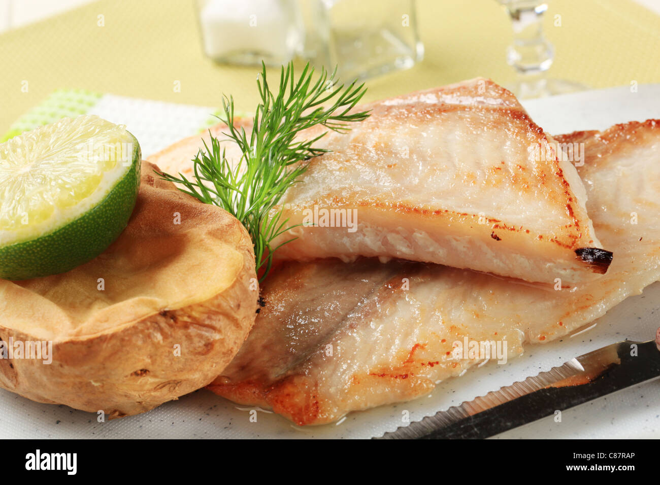 Pan fried white fish fillets with potato Stock Photo - Alamy