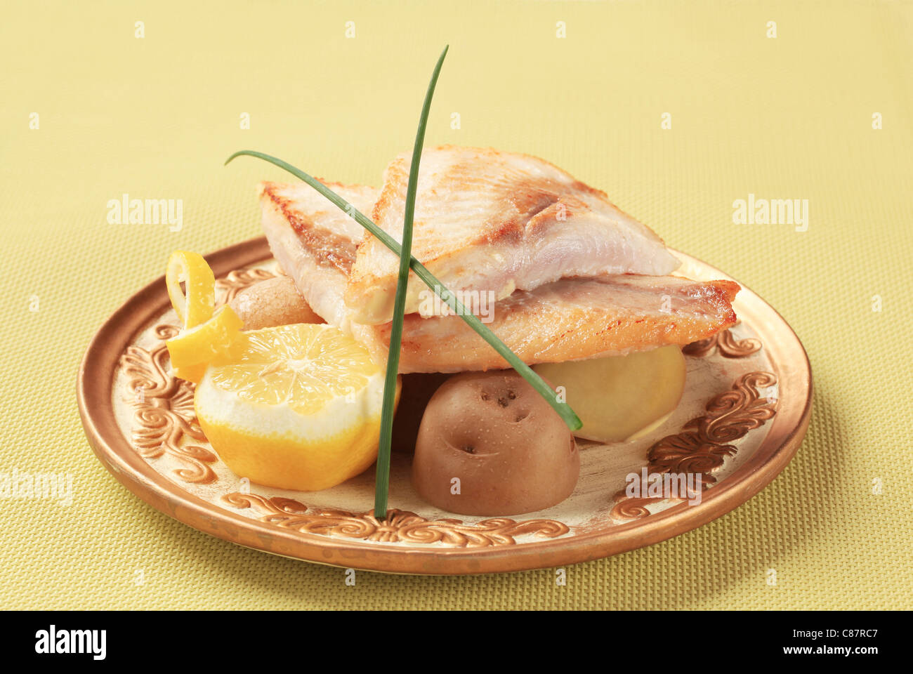 Pan fried white fish fillets with potatoes Stock Photo