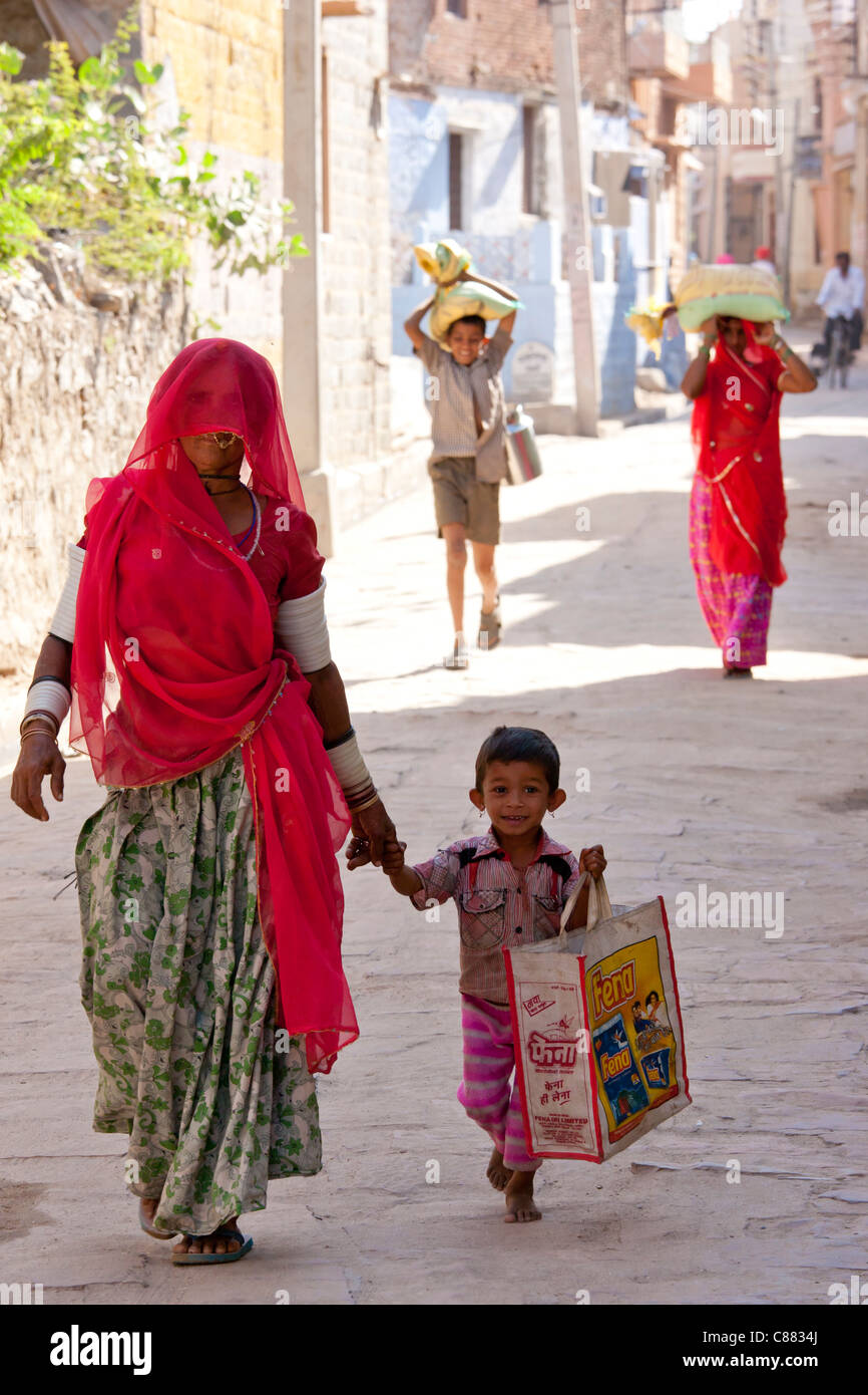 Indian woman shopping with child in the village of Narlai in Rajasthan, Northern India Stock Photo