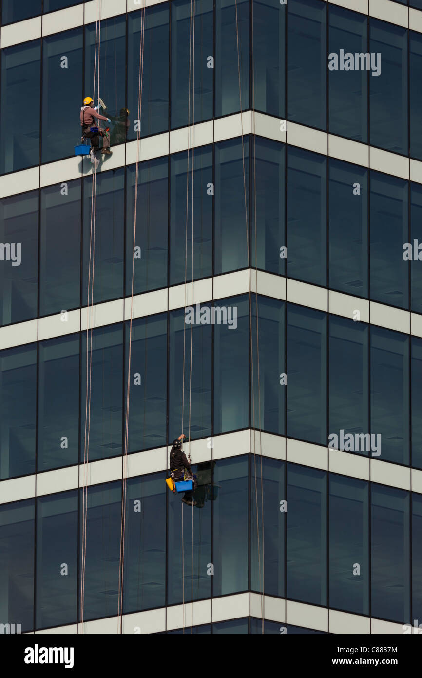 Absiling window cleaners work high above street level of the glass