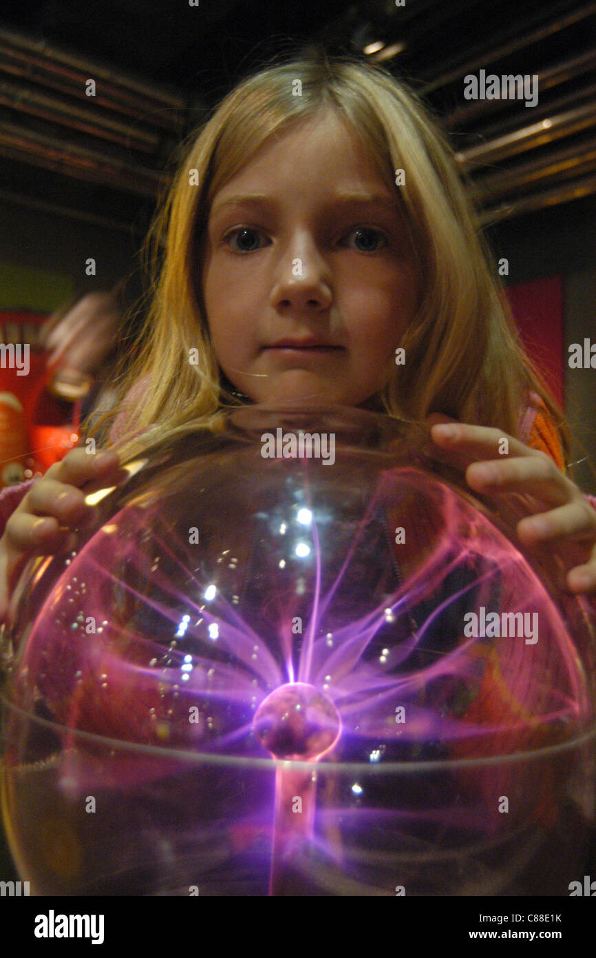 Young visitor examines a plasma sphere on the working exhibit in The Science Museum in London, UK Stock Photo