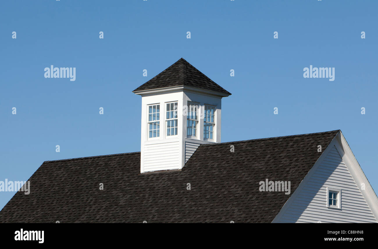 Roof with white cupola with windows and blue sky. Stock Photo