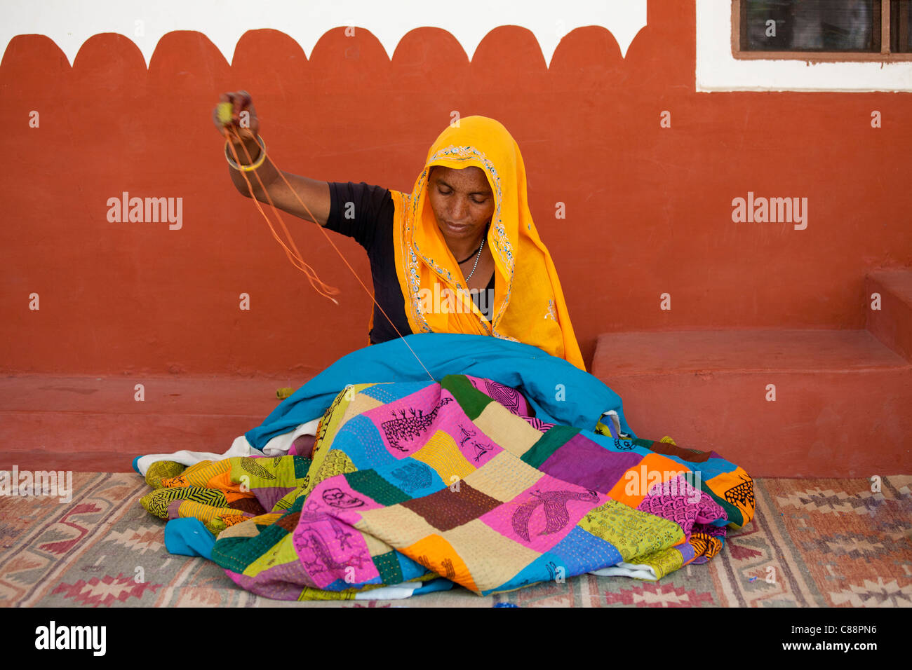 Indian woman sewing textiles at Dastkar women's craft co-operative, the Ranthambore Artisan Project, in Rajasthan, India Stock Photo