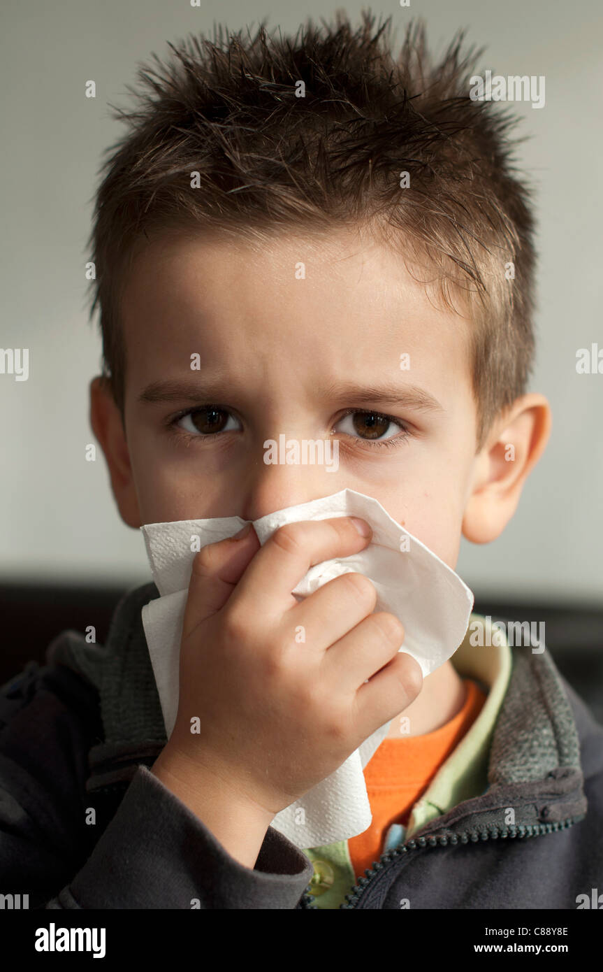 Child suffering from a cold. Cough with a tissue Stock Photo Alamy