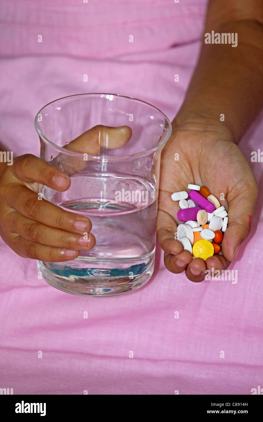 Pills with Water Glass in Human Hand Stock Photo