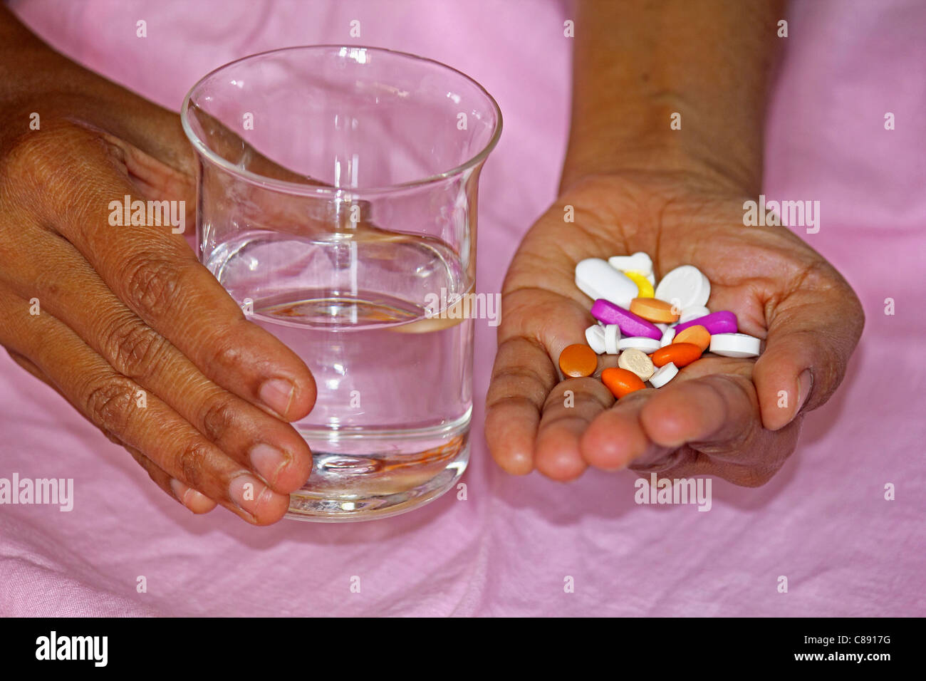 Pills with Water Glass in Human Hand Stock Photo