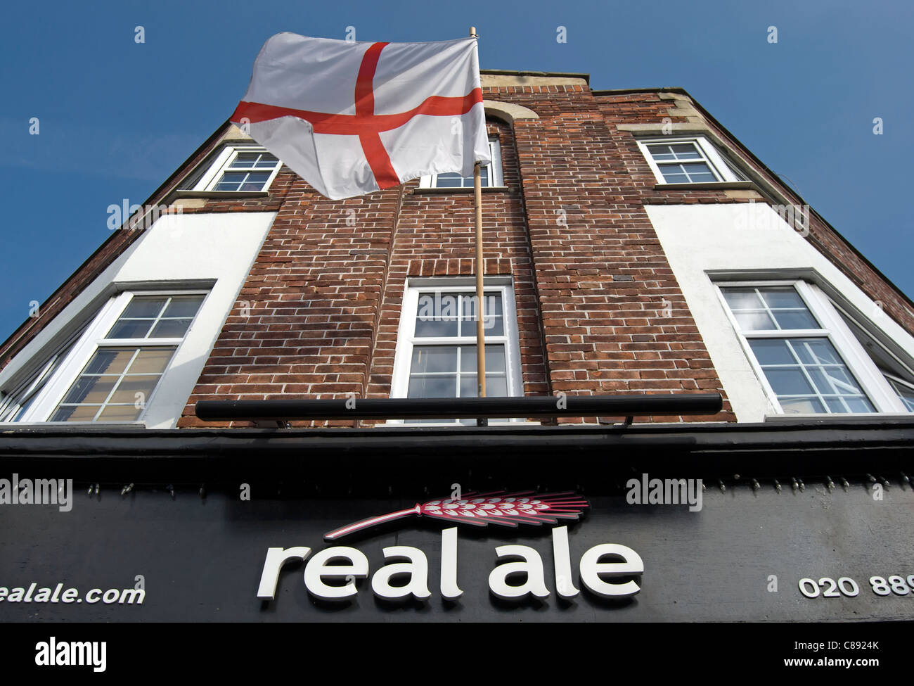 flag of st george above a real ale shop, selling beers from british microbreweries, east twickenham, middlesex, england Stock Photo
