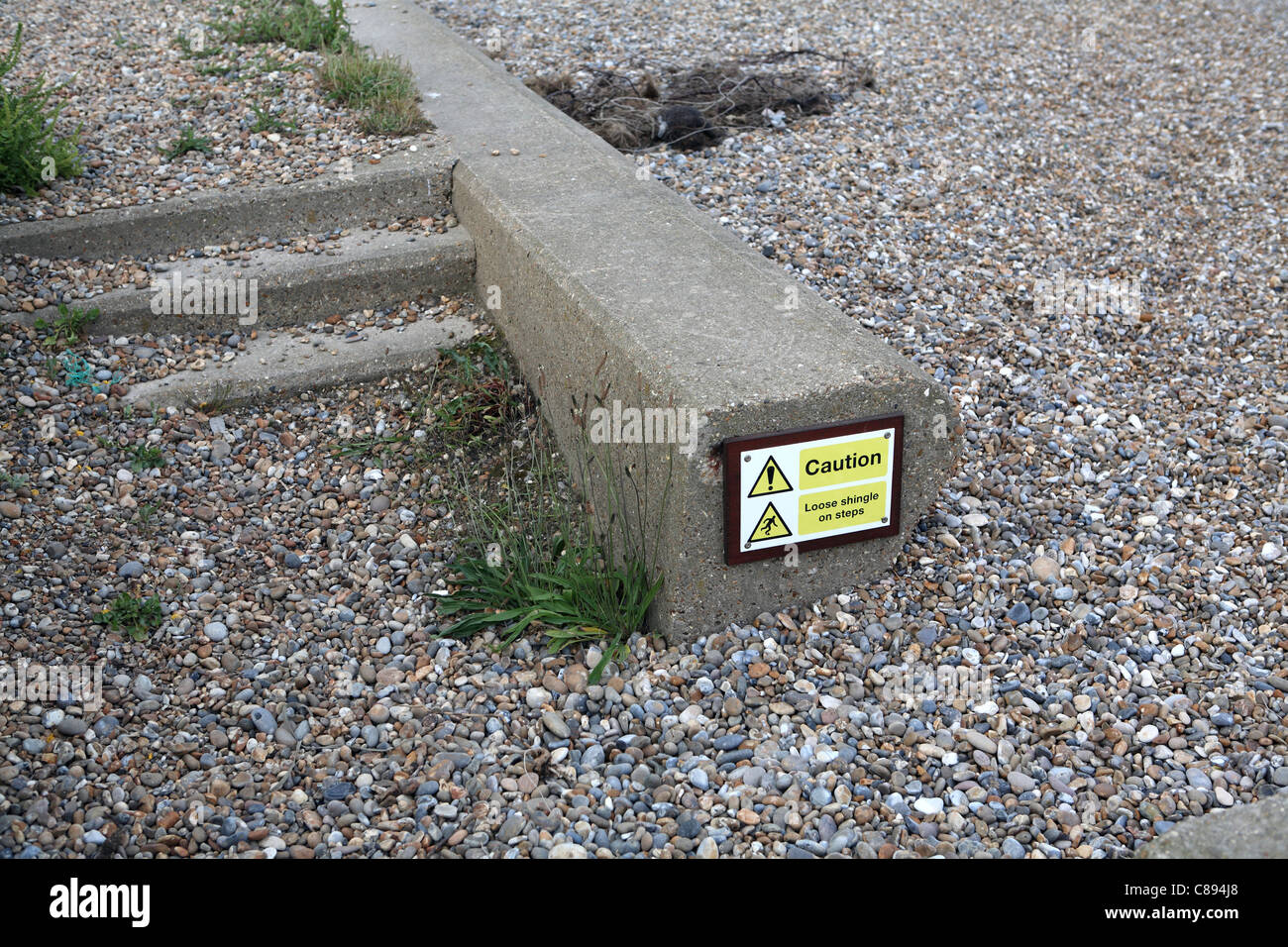 Council sign indicating shingle on steps leading to beach. The shingle is already completely engulfing the whole flight, Suffolk Stock Photo