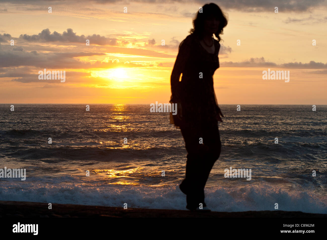 Women walking along beach at sunset Stock Photo - Alamy