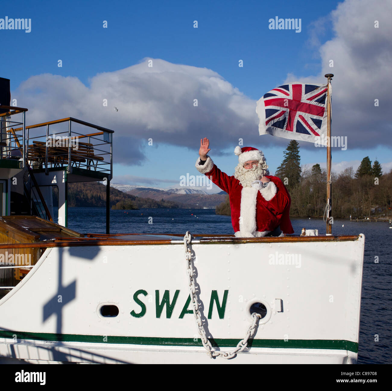 Santa Father Christmas at Bowness Bay in the snow on a bright winters