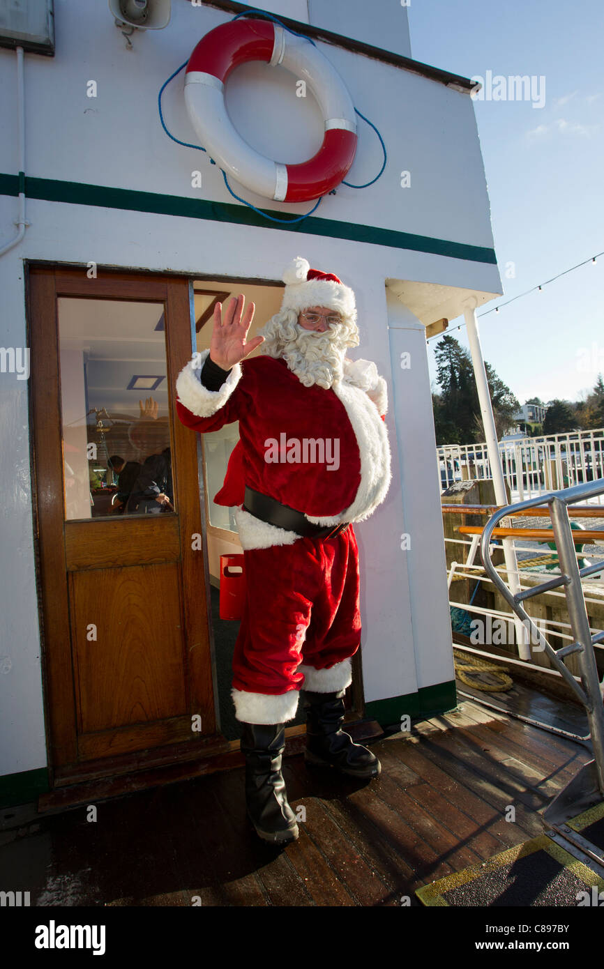 Santa Father Christmas at Bowness Bay in the snow on a bright winters