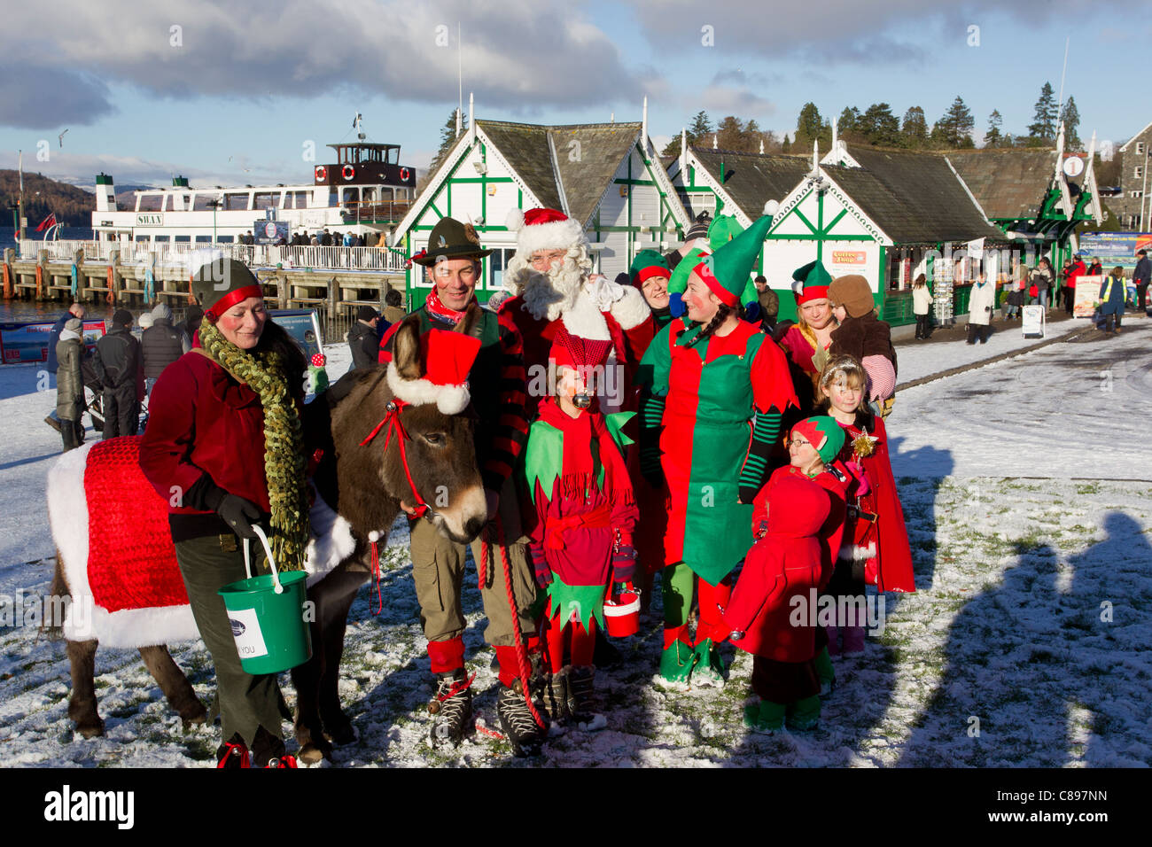 Christmas elves and donkey on Bowness Bay front in the sun & snow Stock