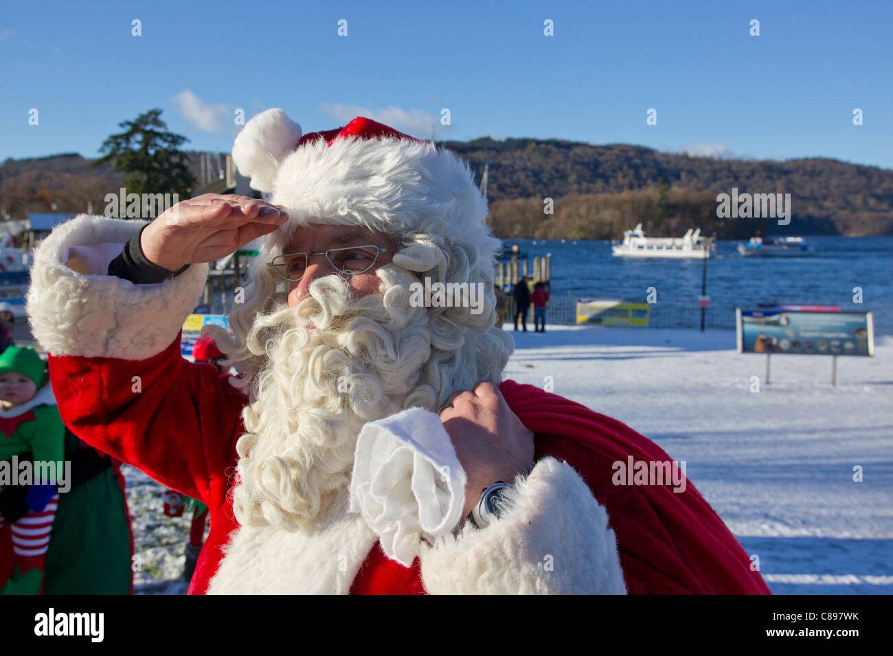 Santa Father Christmas at Bowness Bay in the snow on a bright winters