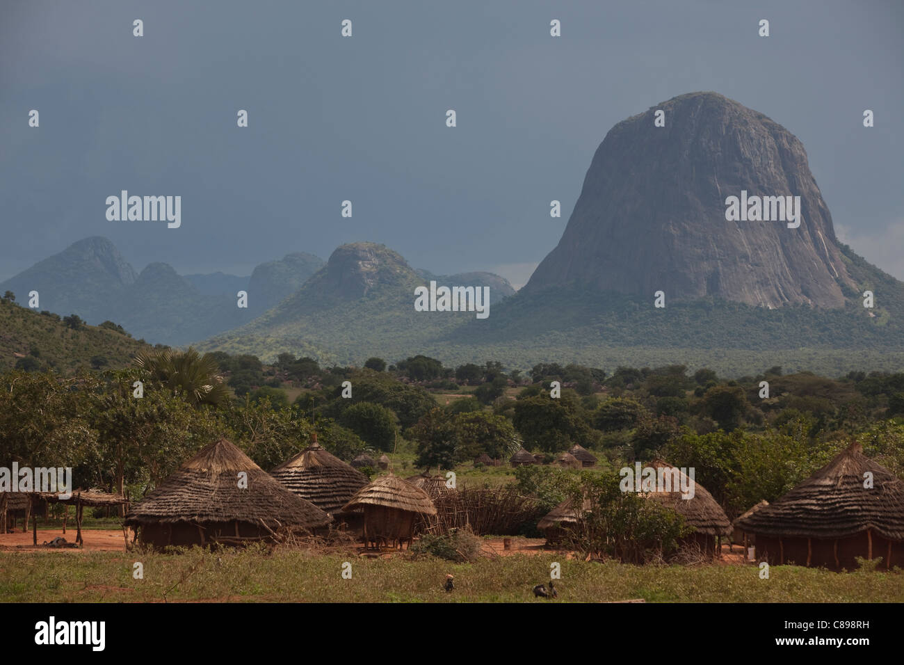 Hills rise above grass huts in Abim district, northern Uganda, East Africa. Stock Photo