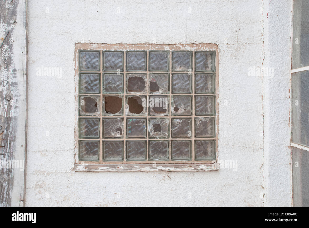 Holes in a glass block window in an abandoned building look almost