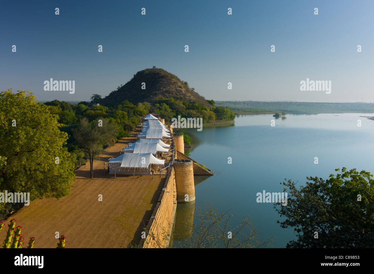 Chhatra Sagar reservoir and luxury tented camp oasis in the desert at Nimaj, Rajasthan, Northern India Stock Photo