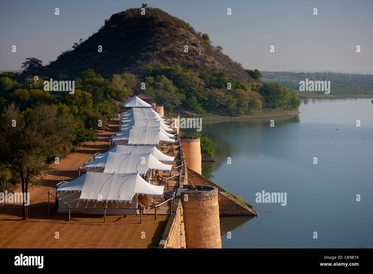 Chhatra Sagar reservoir and luxury tented camp oasis in the desert at Nimaj, Rajasthan, Northern India Stock Photo