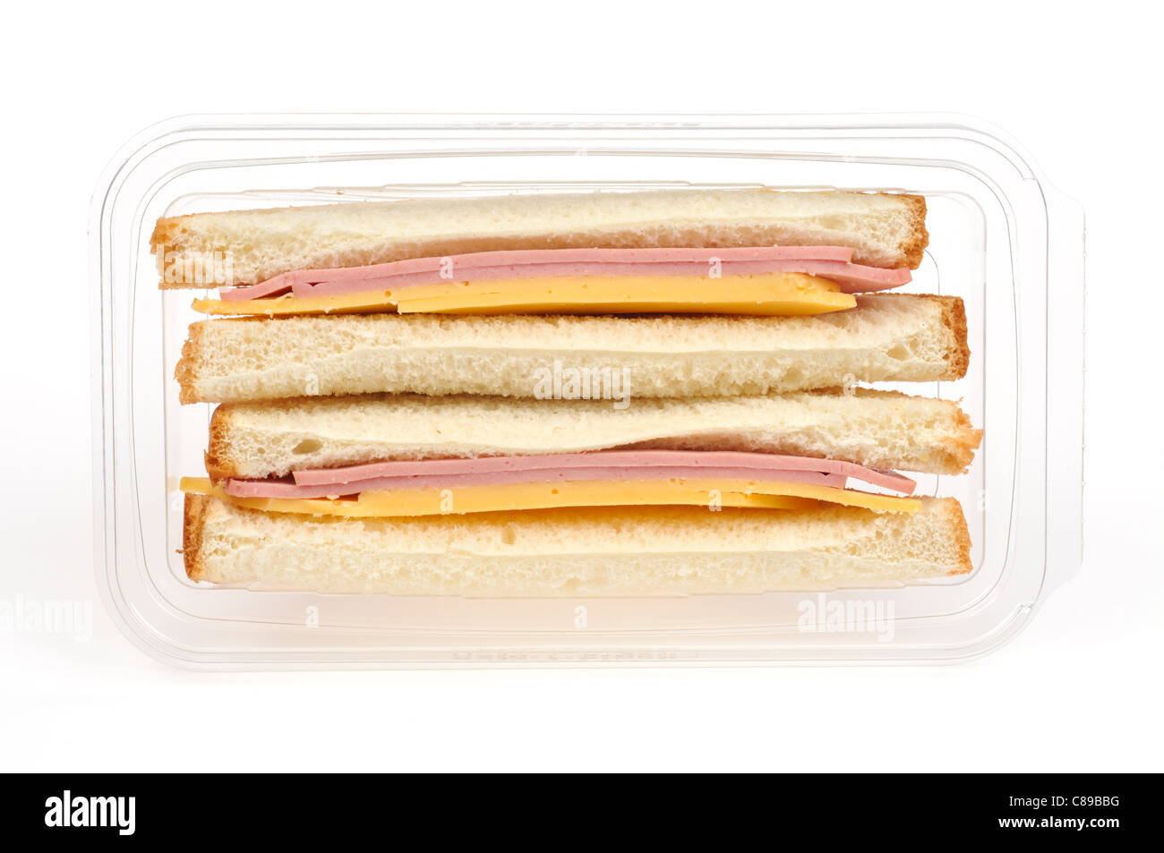 Close-up of bologna and cheese sandwich on white bread in plastic take out container on white background, cutout. Stock Photo