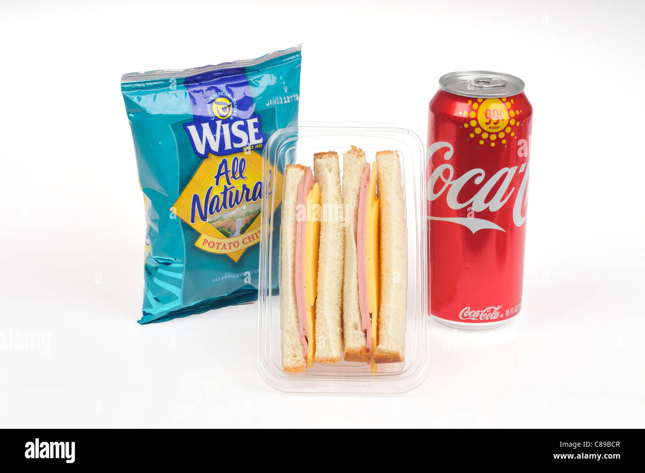 Bologna and cheese sandwich with bag of potato chips and can of coke on white background. Stock Photo