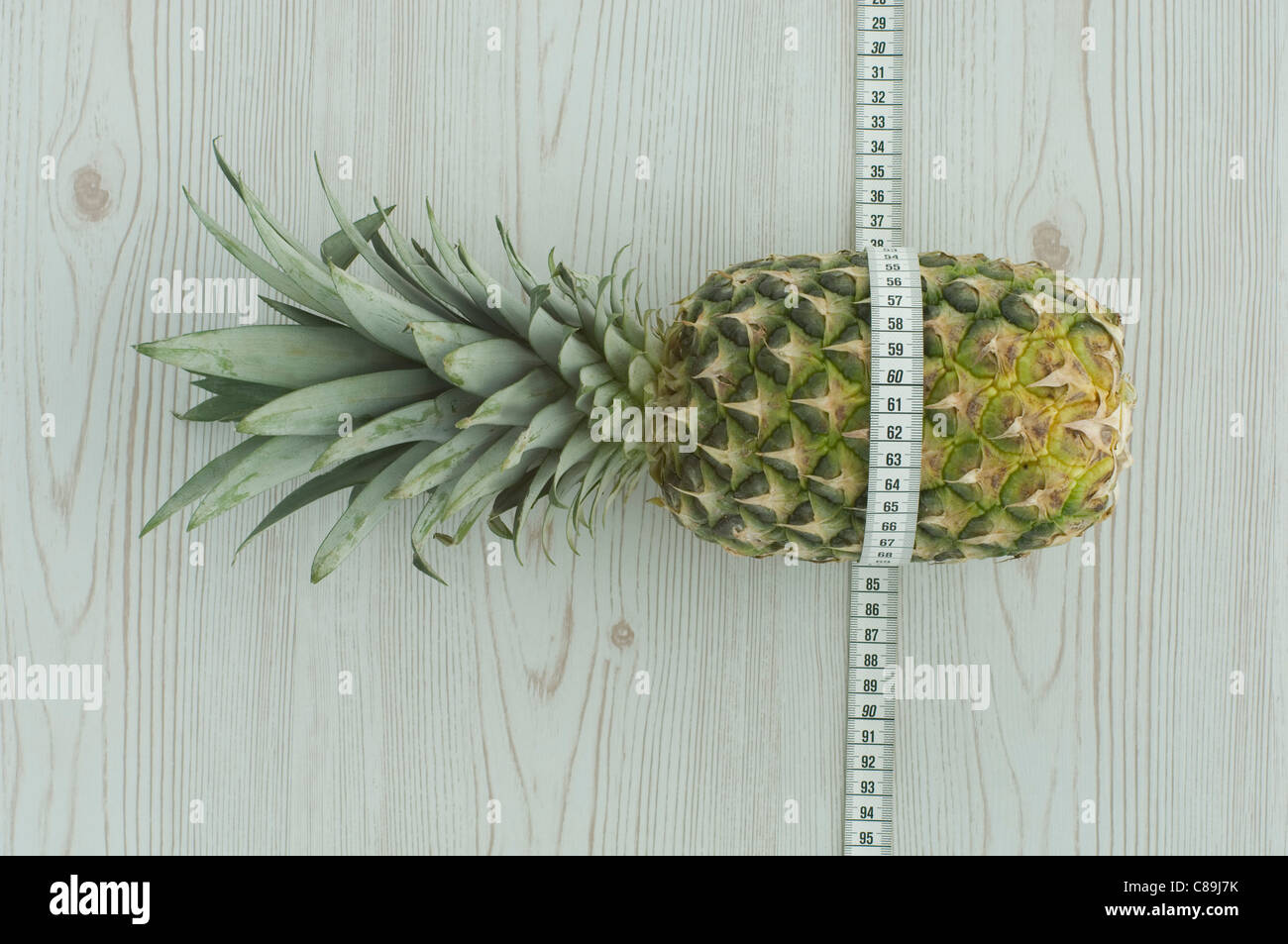 Pineapple wrapped round with measuring tape Stock Photo