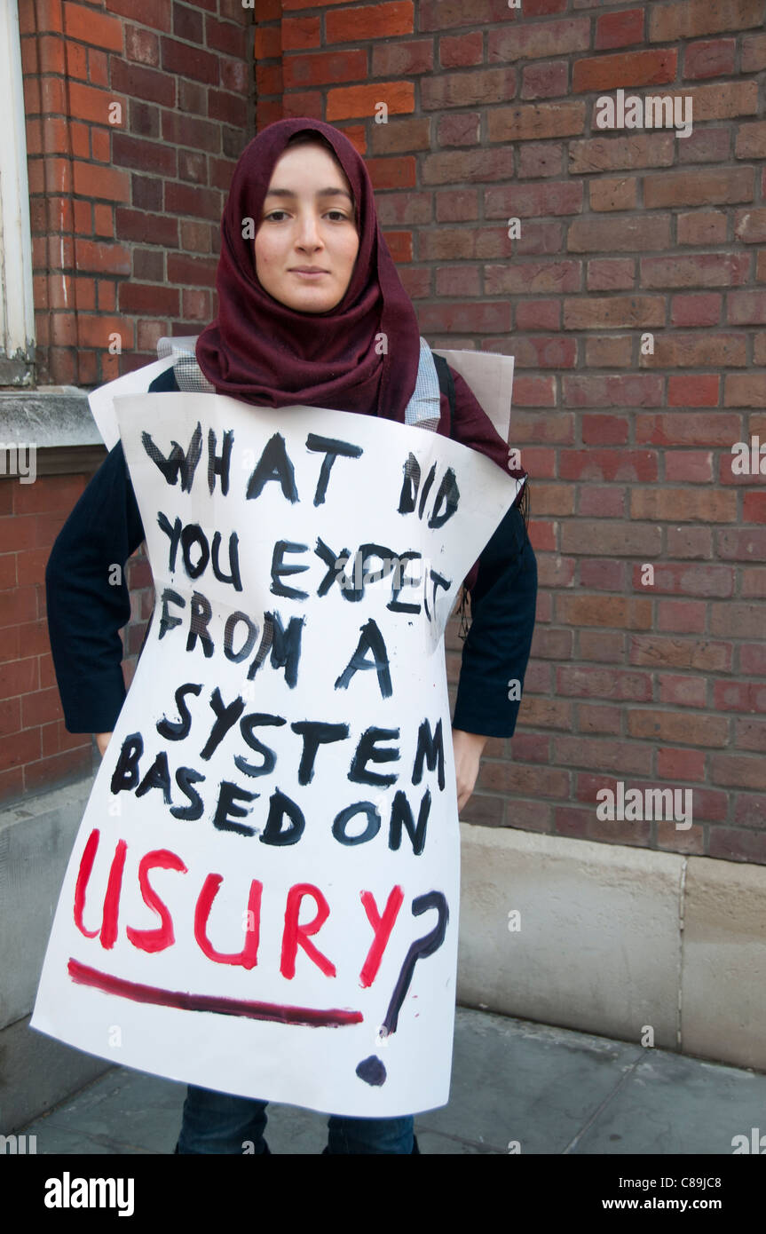 Occupy London.A woman wears a sign saying 'What do expect from a system based on usury' Stock Photo