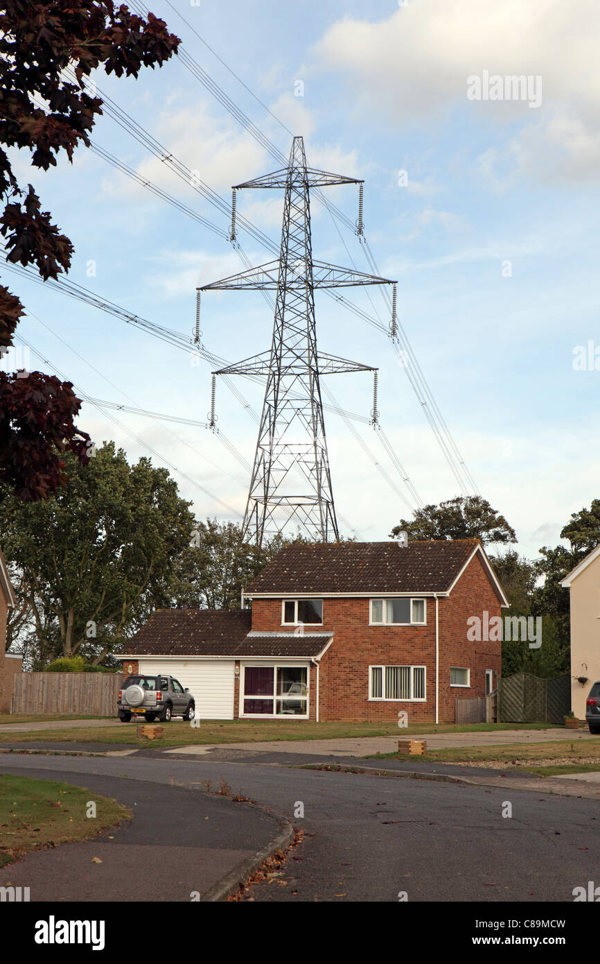 Electricity Pylon behind house, in Suffolk, UK, some research connects pylons to increased cancer risk, eg. leukaemia Stock Photo
