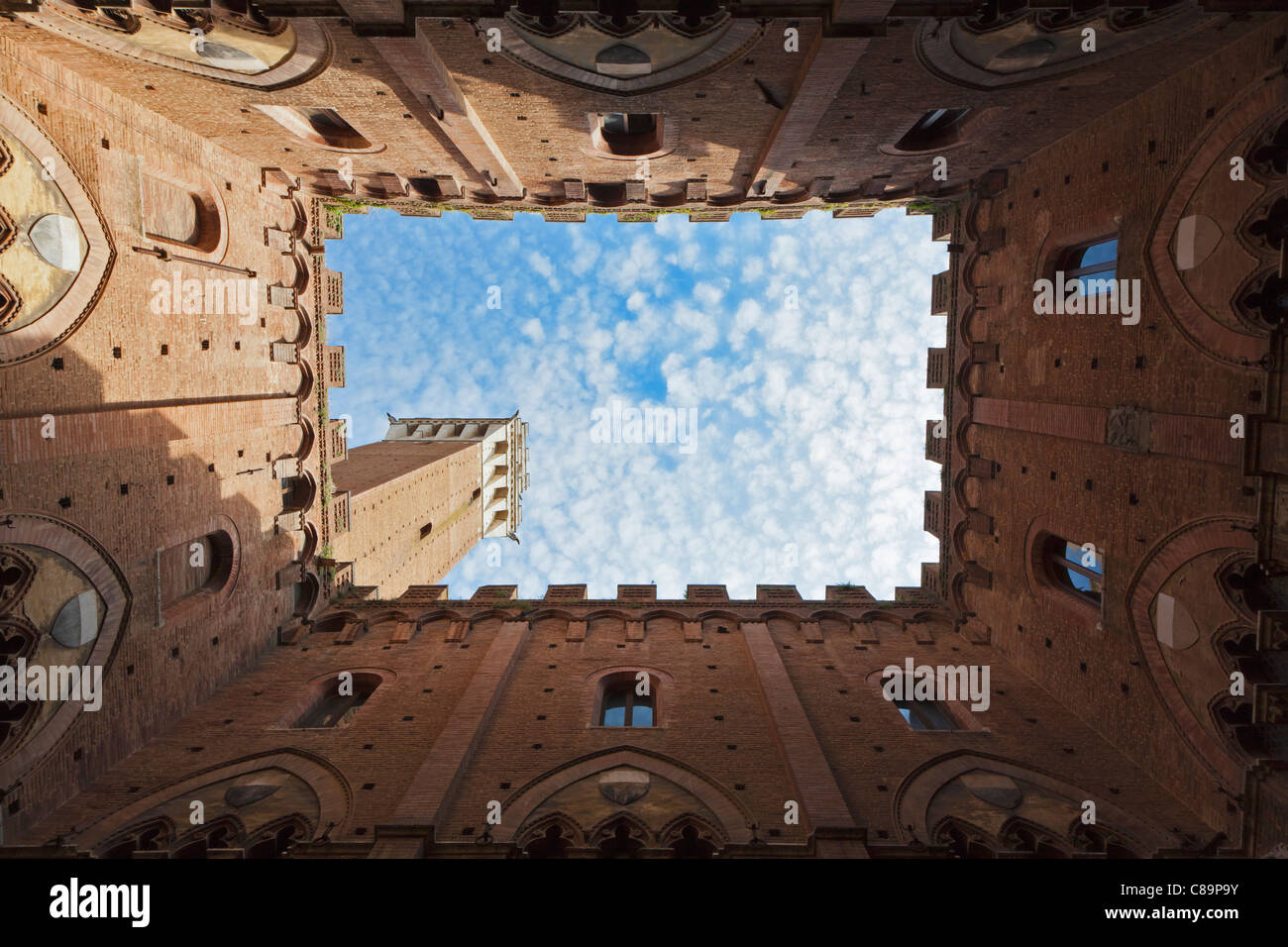 Italy, Tuscany, Siena, Torre del Mangia, Upward view of Palazzo Pubblico from courtyard Stock Photo