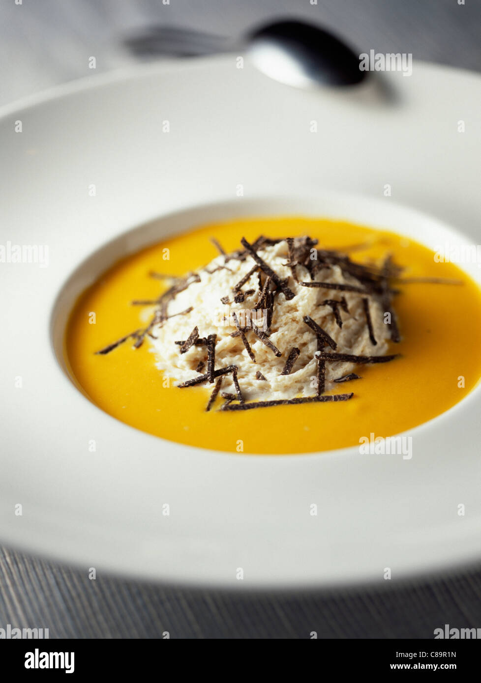 Cream of pumpkin soup with bacon mouuse and truffles Stock Photo