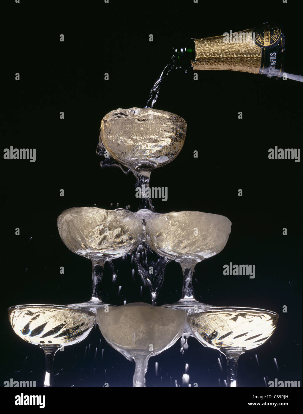 Pouring champagne into pyramid of glasses Stock Photo Alamy