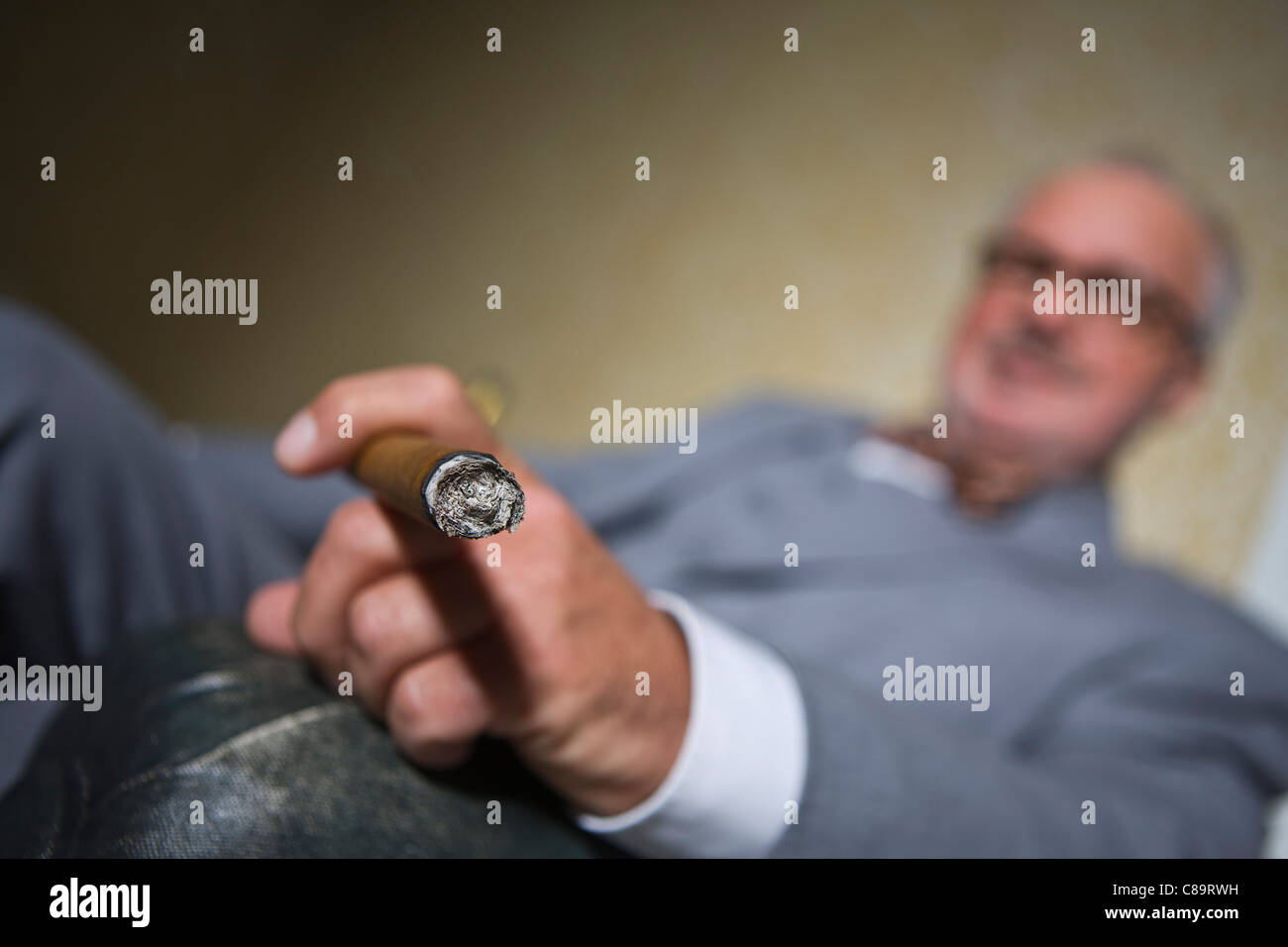 Germany, Braunschweig, Senior man smoking cigar, close up Stock Photo