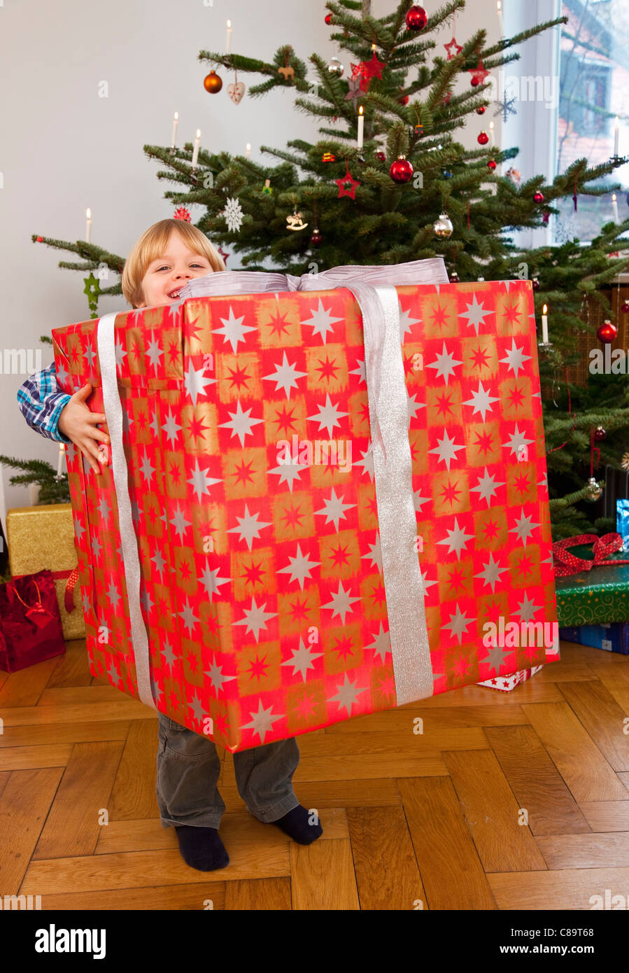 Boy holding big christmas present hi res stock photography and