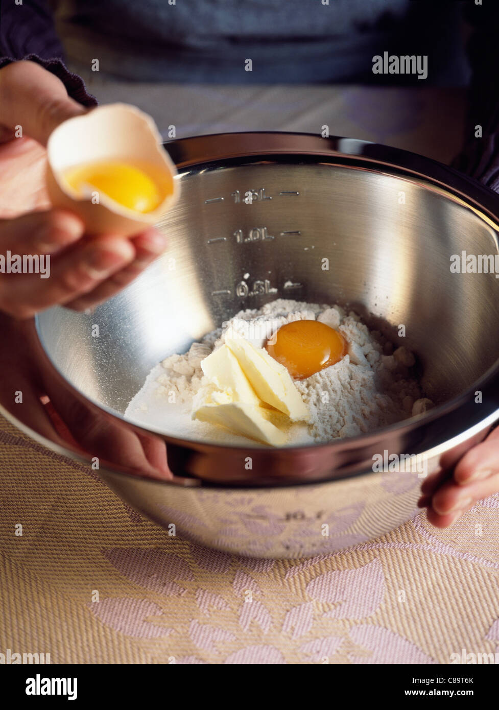 Adding an egg yolk to the flour and butter Stock Photo