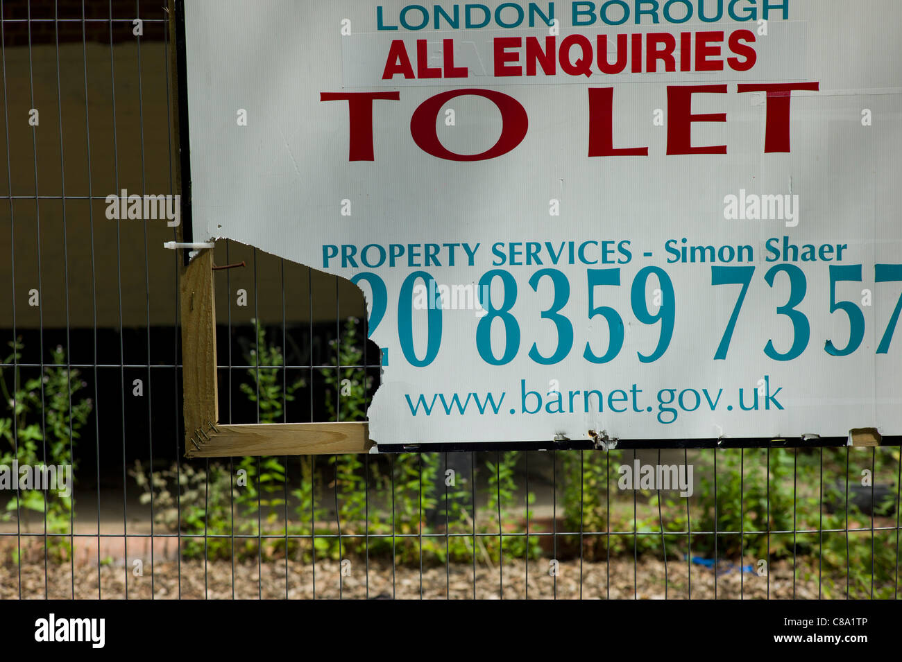 To let sign or board in front of dilapidated and falling down building Stock Photo