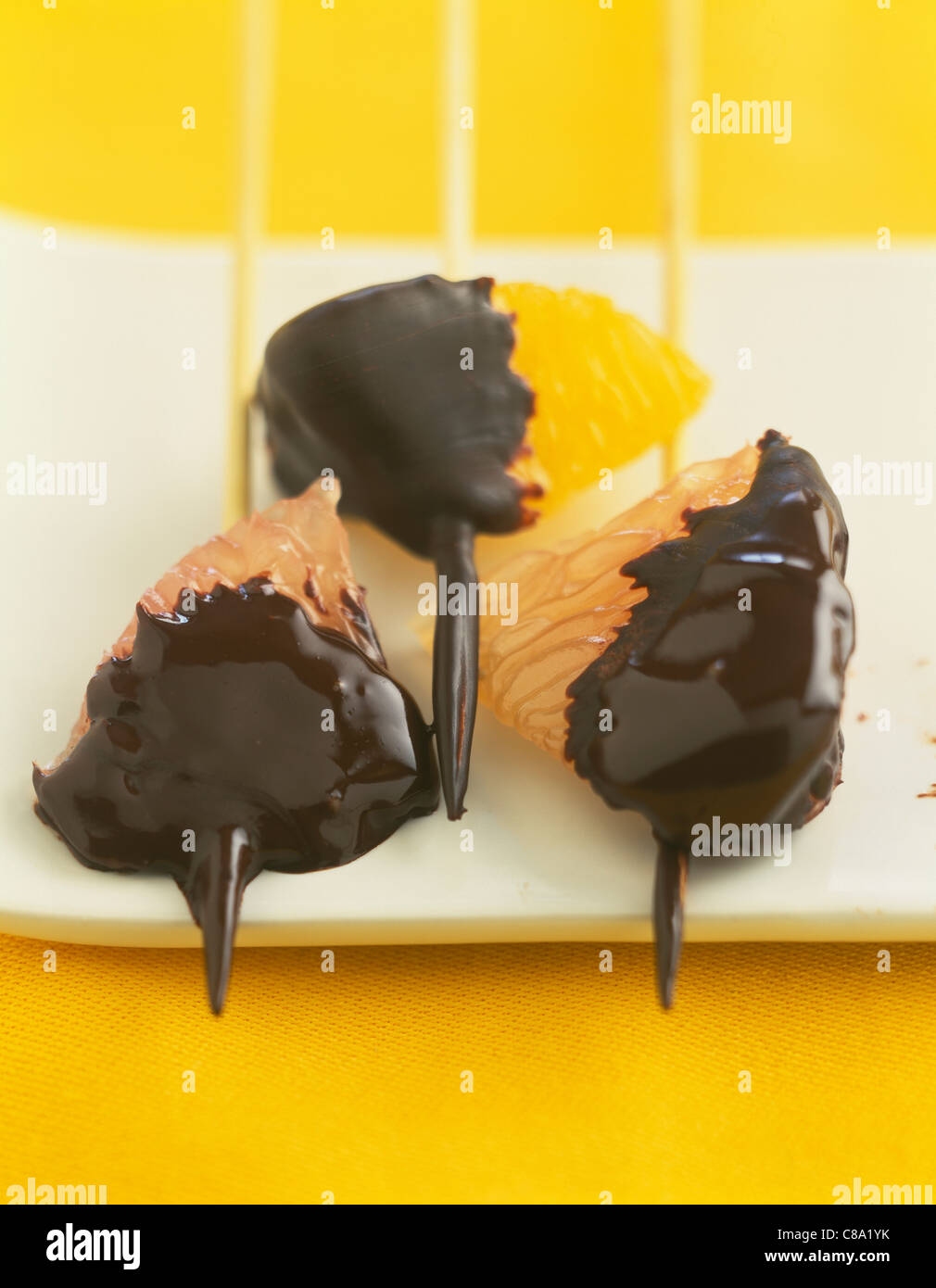 Citrus fruit skewers dipped in melted chocolate Stock Photo Alamy