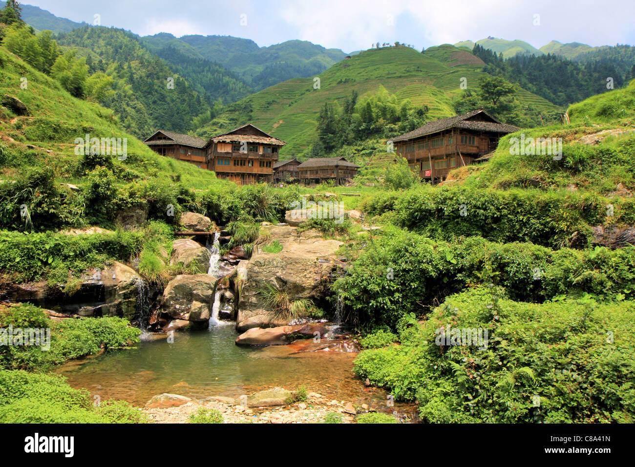 Houses and waterfall in the terraced rice fields area, Ping'an, Guanxi, China Stock Photo