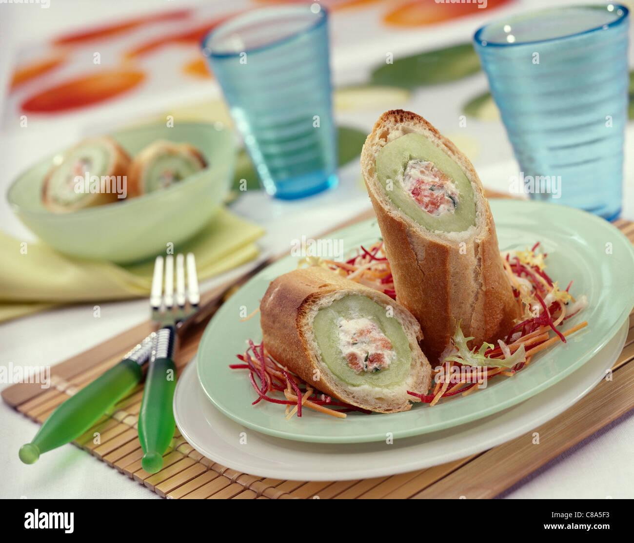 Baguette sections stuffed with cream cheese and cucumbers Stock Photo