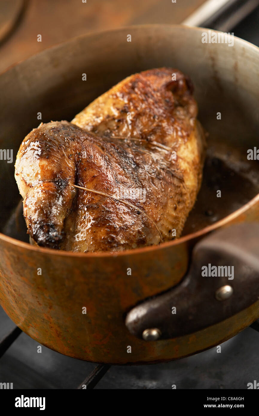 Roast guinea-fowl in a casserole dish Stock Photo