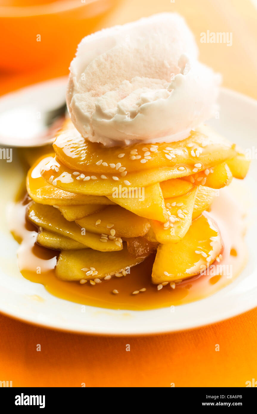 Caramelized pears with sesame seeds and a scoop of ice cream Stock Photo
