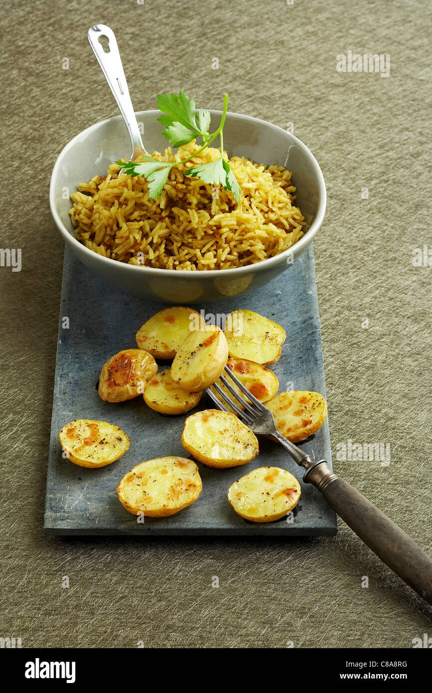 Pilaf rice and roast potatoes Stock Photo Alamy