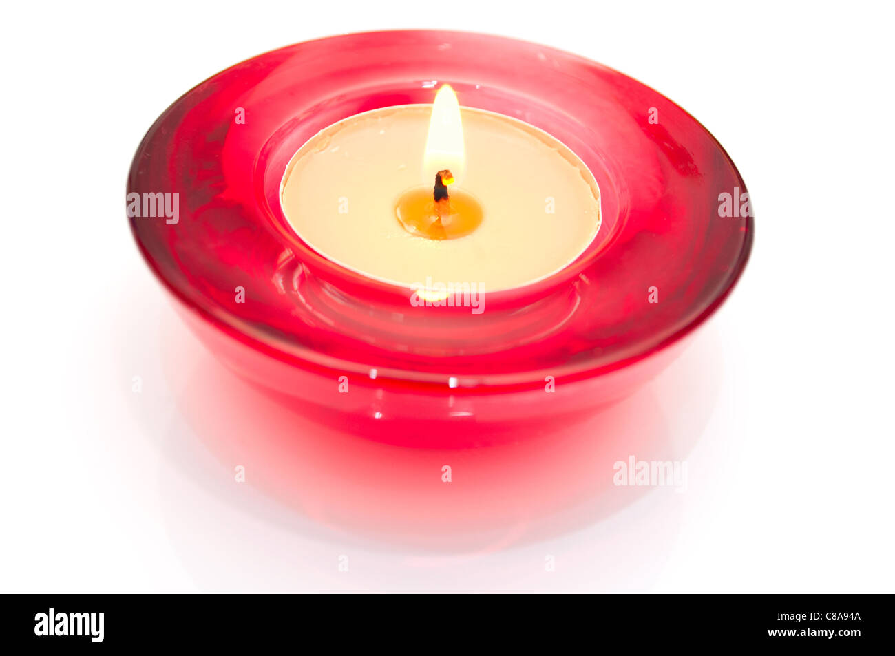 Burning Candle in Red Glass Candlestick on White Background Stock Photo