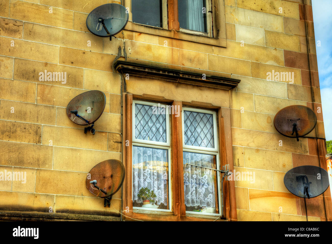 Oban, Scotland, building with large amount of satellite dishes for small area bskyb has window surrounded Stock Photo